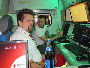 Martin Nickel (links) und Marcel Straub an den Arbeitsplätzen des Einsatzleitwagens 2, der das fahrende Büro des Einsatzleiters ist. Foto: BRK