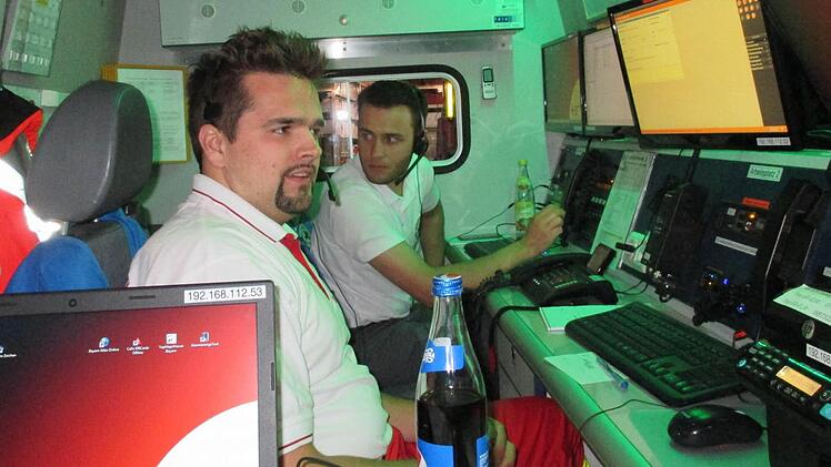 Martin Nickel (links) und Marcel Straub an den Arbeitsplätzen des Einsatzleitwagens 2, der das fahrende Büro des Einsatzleiters ist. Foto: BRK