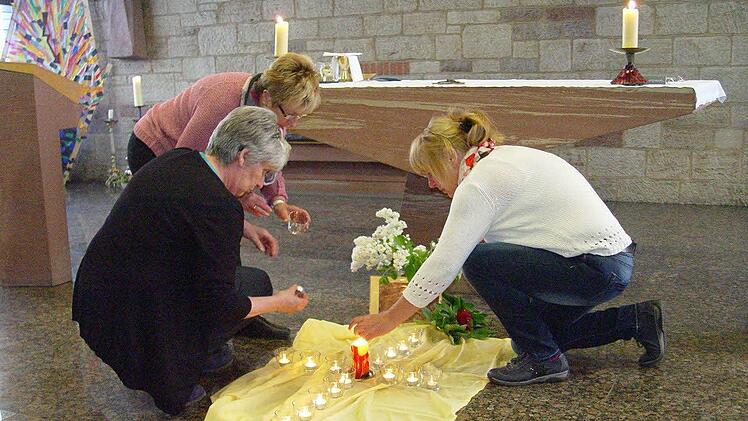 Vor dem Gottesdienst gestalten einige Frauen ein Kerzenkreuz . Foto: Brigitta Kempe-Wolf