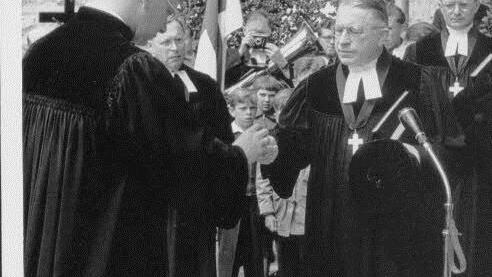 Der erste Pfarrer der Auferstehungsgemeinde, Rudolf Meiser, nimmt am 17. Juni 1956 den symbolischen Schlüssel entgegen.