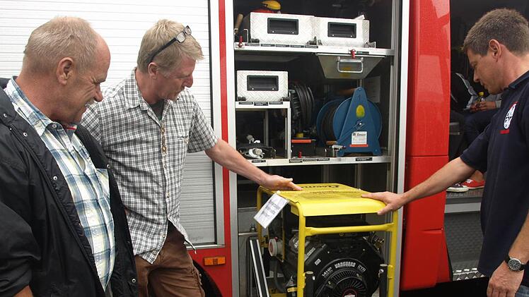 Mit der eigenen Ausrüstung sind die Feuerwehrleute aus  Ebenhausen zufrieden:  der stellvertretende Kommandant Kai Niedergesäß (rechts)  mit Berthold Hofmann (links) und Arnold Geisel am Löschfahrzeug LF 8/6.  Foto: Stefan Geiger