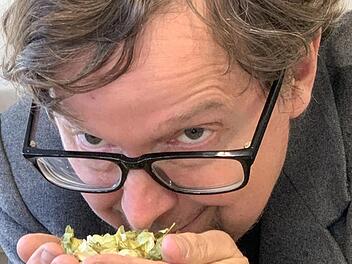 Einmal tief einatmen - Jim Barnes riecht an einer Handvoll Hopfen.  Foto: Sonny Adam