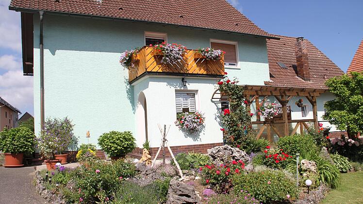 Ein Grundstücksbesitzer hat ein kleines naturnahes Paradies (rechts) mit Hochbeeten, mehreren Insektenhotels, Gemüse und Blumenpflanzen geschaffen. In den Vorgärten fallen prächtige Blumenrabatte auf (links).