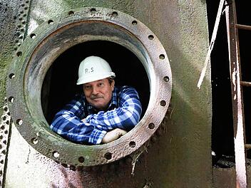 Richard Schmitt ist stolzer Besitzer eines 15 Hektar großen Gelände mitten im Wald bei Ebrach. Mehrere riesige Tanks sind dort versteckt. Der Tank, aus dem Schmitt auf dem Bild blickt, ist allerdings nicht mehr in Gebrauch. Foto: Matthias Hoch