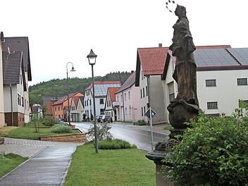 Blick vom alten Stettfelder Rathaus in die Hauptstraße mit der Marienstatue im Vordergrund, den Straßenlampen mit LED-Beleuchtung und der Begrünung der Außenbereiche