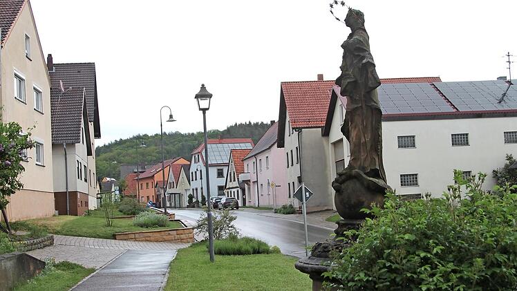 Blick vom alten Stettfelder Rathaus in die Hauptstraße mit der Marienstatue im Vordergrund, den Straßenlampen mit LED-Beleuchtung und der Begrünung der Außenbereiche