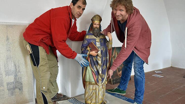 In den letzten beiden Wochen wurde das "Dokumentationszentrum St. Michaelskapelle" in Haßfurt eingerichtet. Christoph Deuter (rechts) vom Kunstreferat des Bischöflichen Ordinariats Würzburg und der Schreiner Uli Römer platzieren gerade eine Statue des Heiligen Bonifatius aus Ton (um 1900).  Fotos: Ulrike Langer