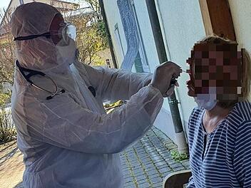 Der Weismainer Arzt Christopher Kirsten nimmt im Hof seiner Praxis einen Abstrich bei einer Patientin vor - in voller Schutzmontur.  Foto: privat