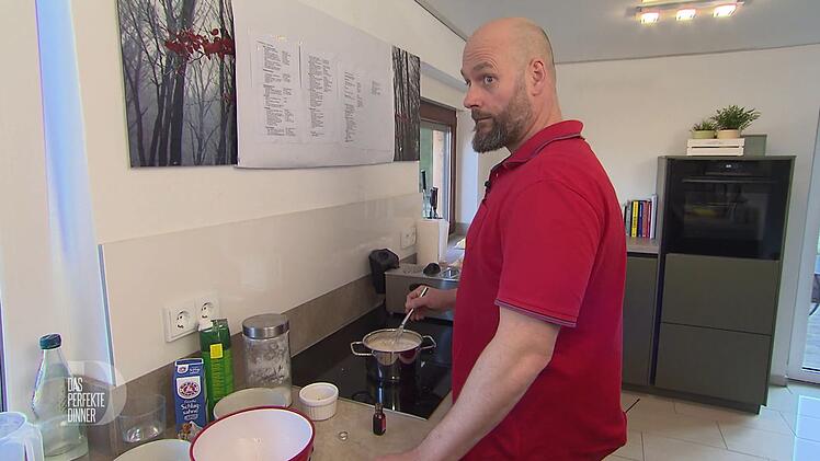 Kei hofft, dass seine Panna cotta diesmal fester wird als beim Probekochen.