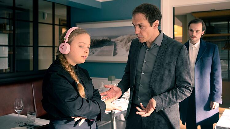 Poul Falk (Rafael Stachowiak, Mitte) k&uuml;mmert sich im Restaurant seiner Schwester Airin um die B&uuml;cher. Er und Restaurantleiter S&ouml;ren Brogaard (Tom Gronau) sorgen sich um die autistische K&uuml;chenhilfe Hanne (Lale Andr&auml;), die zur ermordeten Jorna eine enge Beziehung hatte.