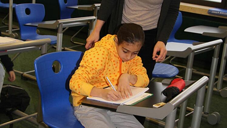 Die zehnjährige Salam übt fleißig Deutsch mit der ehrenamtlichen Lehrerin Bettina van Plüren.