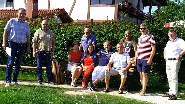 Der Pflasterkreis des Brunnens auf dem Haarther Dorfplatz wird noch etwas erweitert. Damit soll verhindert werden, dass zu viel Matsch im Rasen verteilt wird. Foto: Norbert Karbach