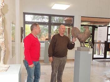 Der Schulleiter der staatlichen Berufsfachschule für Holzbildhauer Rudolf Schwarzer (rechts) und Martin Bühner stellen die neue Ausstellung in der Aula der Schule vor. Foto: Marion Eckert