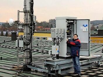 Nach der Modernisierung braucht die Vodafone-Mobilfunkanlage auf dem Dach der Hochschule Coburg deutlich weniger Energie als früher, erläutert Oliver Baumann, Leiter der Netzoptimierung Süd. Foto: Ulrike Nauer