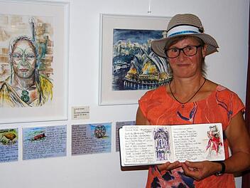 Gertrud Gerlach stellt aktuell 20 Aquarelle im Golfclub aus. Das Foto zeigt im Hintergrund eine Abbildung des Opernhauses von Sydney und das Bildnis eines Maori-Häuptlings, in der Hand hält sie ihr Skizzen-Tagebuch.  Fotos: Klaus Werner