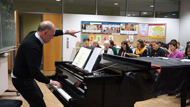 Ronald Scheuer stimmt die ersten Töne auf dem Flügel an , der Chor beginnt zu singen und letztlich gibt es das "Daumen hoch" des Chorleiters.
