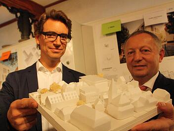 Architekt Thomas Steinle und Landrat Thomas Bold mit dem Modell des Erweiterungsbaus: Durch die zum Teil zwei- und zum Teil dreigeschossige Bauweise fügt sich das Gebäude (Bildmitte) gut in das Ensemble zwischen Rathaus (vorne), Jakobuskirche (rechts) und Landratsamt (dahinter) ein. Fotos: Ralf Ruppert