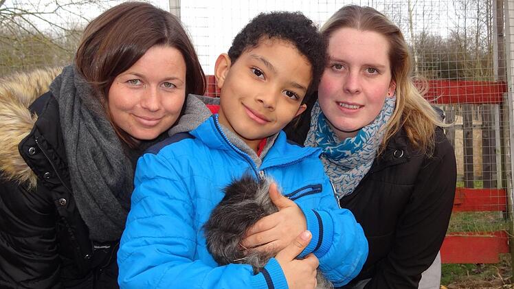 Alle zusammen hoffen auf viele Besucher beim Winterfest in der Gemünder Mühle (von links): Die Einrichtungsleiterin Frauke Adams, der siebenjährige Rafael und sein Meerschweinchen und die Betreuerin Nadine Zeller. Der Erlös des Festes wird an den Verein Rüsselheim, ein Verein zur Rettung von Schlachttieren, gespendet. Foto: Johanna Eckert