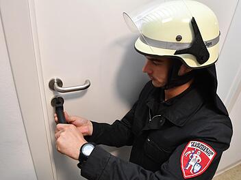 Sebastian Kraus zeigt, wie die Feuerwehr eine Tür im Notfall mit einen Knackrohr öffnet.  Foto: Ronald Rinklef