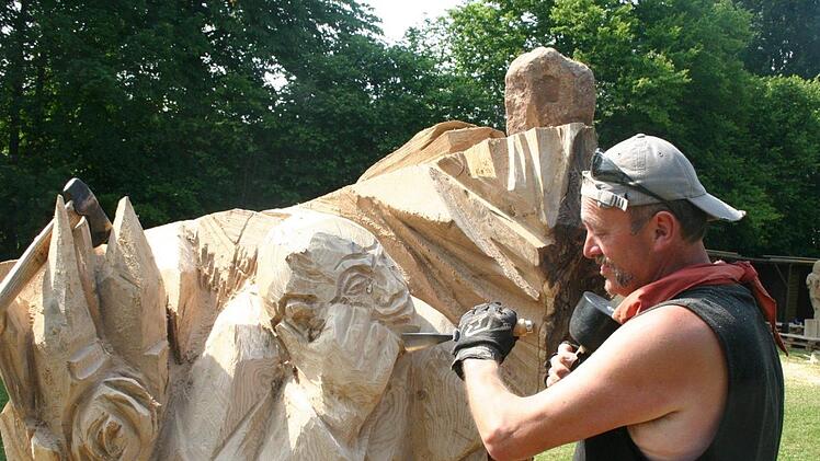 Der Künstler Heinz Hubert Günther beim Bearbeiten seiner Skulptur im Juni 2010 auf dem Seßlacher Symposium. Die Holzplastik steht heute am Pilgerweg bei Schönbrunn.Matthias Einwag