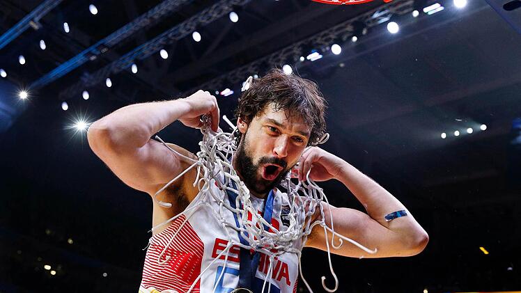 Sergio Llull hat als Trophäe das Korbnetz abgeschnitten und sich um den Hals gehängt. Foto: Yoan Valat/dpa