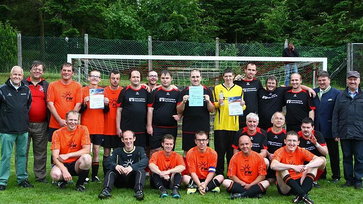 In den orangen Trikot der Landesliga-Sieger Dillingen, in den dunklen Trikots der Zweite aus Hammelburg. Mit im Bild (von links) BFV-Bezirksehrenamtsreferent Siegfried Tabbert, TSV-Vorsitzender Richard Ultsch sowie (von rechts) Sponsor Reimund Grass und Landrat Klaus Peter Söllner. Foto Monika Limmer