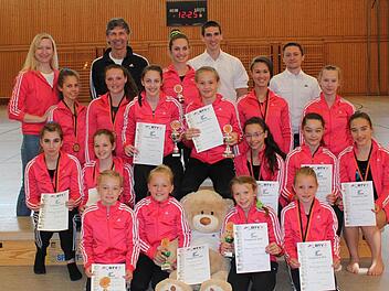 Strahlende Gesichter: Die Geräteturnerinnen der TS Herzogenaurach und das Trainerteam um Peter Müller (hinten, 2. v. r.) waren rundum zufrieden mit dem Auftritt beim Gaupokal in Röttenbach. Foto: privat
