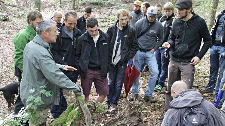 Förster Wolfgang Gnannt (vorne links) mit Schülern der Meisterschule für das Schreinerhandwerk in Ebern im Käppeleswald bei einer Bodenbestimmung. Mit beim Jubiläumswaldgang dabei war Schulleiter Oliver Dünisch (3. von links).  Fotos: Helmut Will