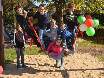 Pfarrer Karl-Theodor Mauer segnete die vom Gartenbauverein und Kleiderbasarteam für 3000 Euro gestiftete Nestschaukel, die gleich darauf von den Reither Kindern in Beschlag genommen wurde. Foto: Peter Rauch