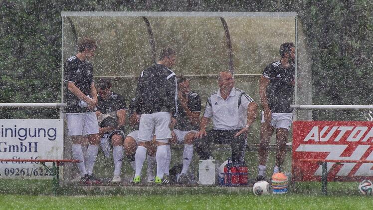In der Hoffnung auf eine Fortsetzung des Spieles blieben die Redwitzer Einwechselspieler bei strömendem Regen noch auf der Bank . Foto: Heinrich Weiß