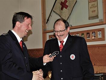 Der bisherige BRK-Bereitschaftsleiter Thomas Menz (45) übergibt seinem Nachfolger Robert Weber (55) die neuen Schulterklappen mit vier Sternen.  Fotos: Sigismund von Dobschütz