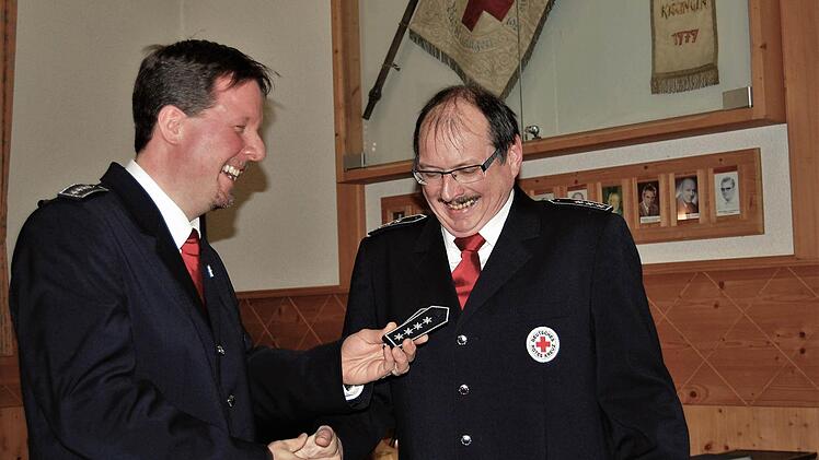 Der bisherige BRK-Bereitschaftsleiter Thomas Menz (45) übergibt seinem Nachfolger Robert Weber (55) die neuen Schulterklappen mit vier Sternen.  Fotos: Sigismund von Dobschütz