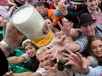München: Besucher freuen sich beim Auftakt zum Oktoberfest über ihr erstes Bier. Ein Liter Bier kann im Laden 60 Cent oder elf Euro kosten. Der Durchschnittspreis ist dieses Jahr gestiegen. Foto: Sven Hoppe/dpa