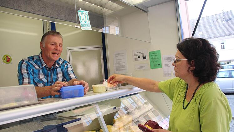 Jutta Wittmann holt sich ihren K&auml;se bei Direktvermarkter Michael Zeitz auf dem Rathausplatz. Foto: Benedikt Borst