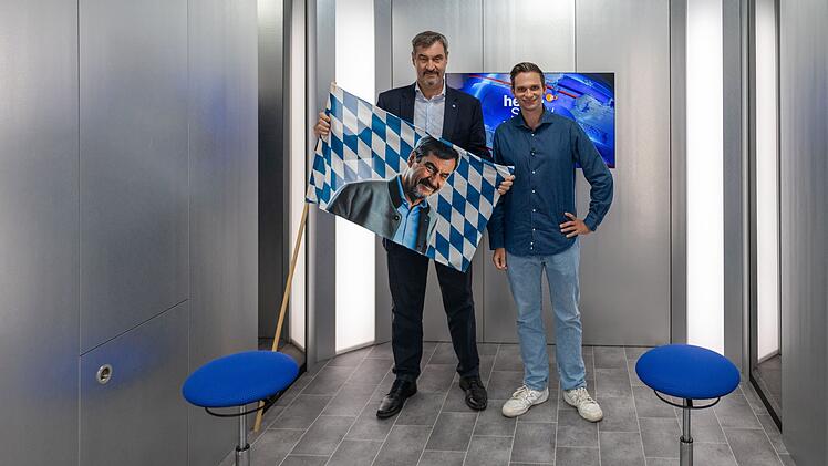 Ein Vier-Augen-Gespräch auf acht Quadratmetern in einem Fahrstuhl: Dem stellen sich Gastgeber Fabian Köster (rechts) und der bayerische Ministerpräsident Markus Söder.