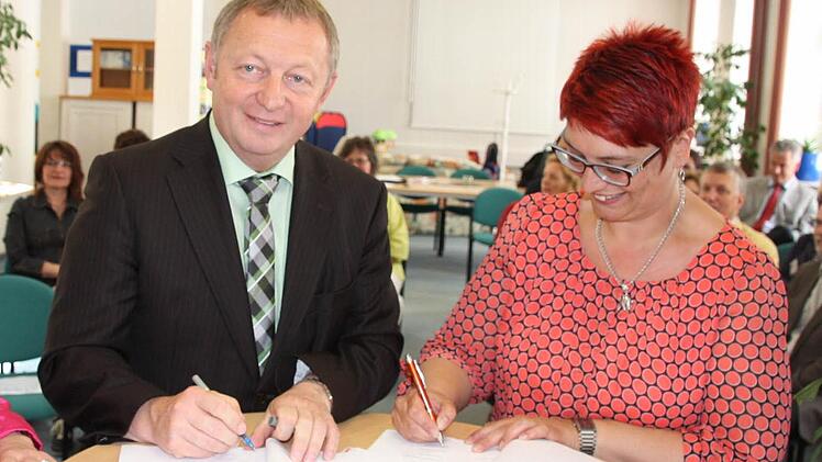 Landrat Thomas Bold und Vorstandsmitglied Karen Pohle unterschreiben die Vereinbarung.