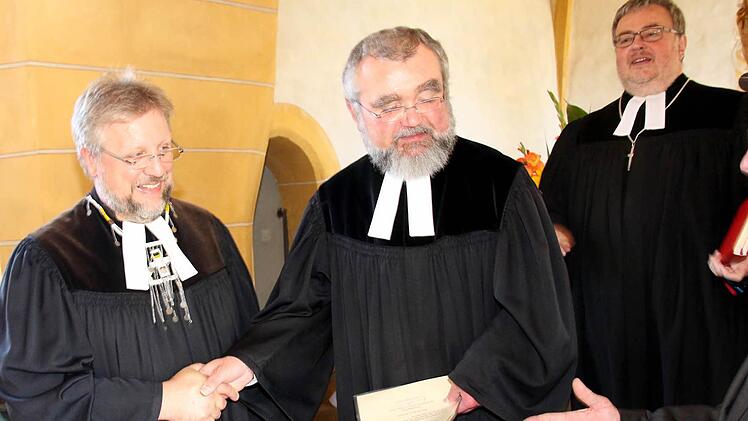 Pfarrer Alexander Rosenmeyer legte das Pfarramt in die Hände von Pfarrer Wolfgang Leikert. Dekan Christoph Liebst freut sich darüber (von links). Foto: Michael Stelzner