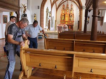 Viele Händ machen schnell ein End, sagt das Sprichwort. Am Samstag wurden die 14 Kirchenbänke nach der Renovierung zurück in die Pfarrkirche von Wachenroth gebracht. Fotos: Evi Seeger