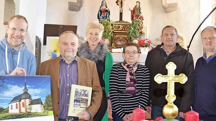 In der Kirchengemeinde Hain herrscht große Freude über die Abbildung der Dreifaltigkeitskirche in einem bundesweit erscheinenden Kalender der Stiftung zur Bewahrung kirchlicher Baudenkmäler in Deutschland. Das Bild zeigt (von links): Ulli Naefken (mit Kalender und Kirchenbild), Bernd Graf (mit heimatkundlichem Jahrbuch), Sabine Schmidt, Elfriede Ultsch, Reinhard Müller und Pfarrer Reinhold König. Foto: Karl-Heinz Hofmann