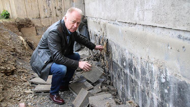 Bürgermeister Helmut Blank zeigt das Problem. Beim Entfernen der Bimssteine wird auch die Abdichtung der Halle beschädigt. Während der Projektsteuerer das auf falsche Bauausführung zurückführt, sehen einige Stadträte in den jetzigen Arbeiten das Problem. Thomas Malz