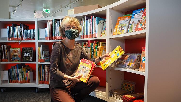 Brigitte Rößler-Reuß, Leiterin der Mediathek Neustadt, räumt die Regale in der neu gestalteten Kinderecke ein.  Fotos: Cindy Dötschel