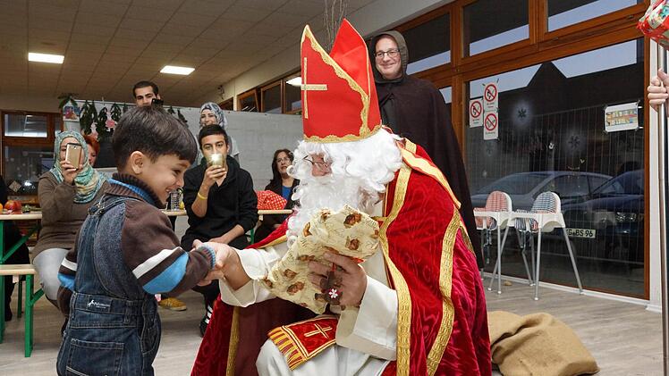 Harald Drescher verteilt als Nikolaus Päckchen an die Flüchtlingskinder. Foto: Arkadius Guzy