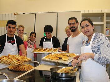 Gemeinsames Kochen in der Schulküche: Fadi Alibrahim (von links), Sozialpädagogin Irene Jonda, Nasima Noori, Fuaad Keher, Klassenleiterin Doris Peter, Abdulbasir Noori und Fereshteh Bayat bereiten Pita und mehr zu, um mit ihren Mitschülern in Kontakt zu kommen. Abschmecken war dabei tabu. Fotos: Ralf Ruppert