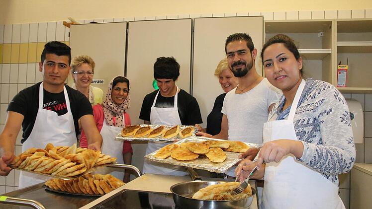 Gemeinsames Kochen in der Schulküche: Fadi Alibrahim (von links), Sozialpädagogin Irene Jonda, Nasima Noori, Fuaad Keher, Klassenleiterin Doris Peter, Abdulbasir Noori und Fereshteh Bayat bereiten Pita und mehr zu, um mit ihren Mitschülern in Kontakt zu kommen. Abschmecken war dabei tabu. Fotos: Ralf Ruppert