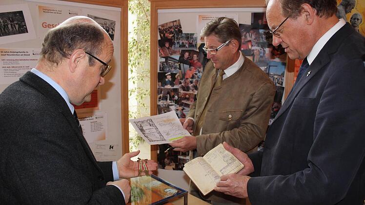 Präses Dekan Peter Brandl, Bürgermeister Heinz Richter und Kolpings-Vorsitzender Rainer Obermeier mit alten Handwerkerbüchlein.  Foto: fra-press