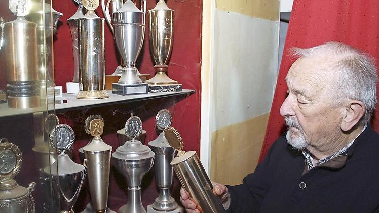 Noch rund 100 Trophäen und Pokale befinden sich in verschiedenen Vitrinen im Vereinslokal Göller. Der Zeiler Privatkegelclub "Goldene 13" möchte diese aus Platzgründen nun verschenken. Vorsitzender Anton Brüger schaut hier einen besonders alten Pokal an.  Foto: Ralf Naumann
