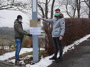 Moritz Goldbach (FH-Praktikant) und Edwin Erich (FSJ) haben die Plakate für den Advents- und Weihnachtsweg rund um den Volkersberg angebracht. Foto: Marion Eckert