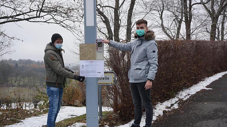 Moritz Goldbach (FH-Praktikant) und Edwin Erich (FSJ) haben die Plakate für den Advents- und Weihnachtsweg rund um den Volkersberg angebracht. Foto: Marion Eckert