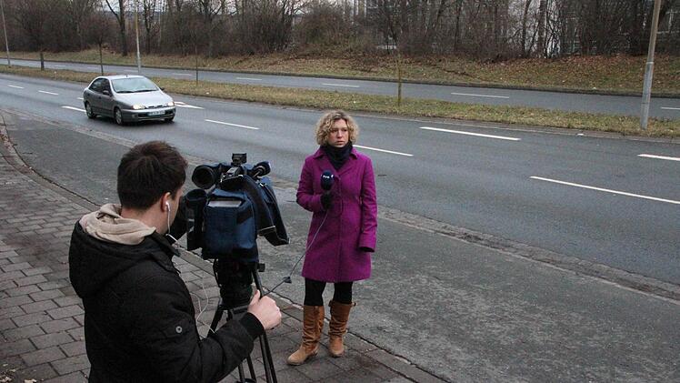 Ein Team von TV Oberfranken vor Ort: Im Hintergrund sind die Spuren des Unfalls in der Böschung zu sehen. Foto: Josef Hofbauer