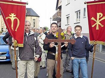 Die Poppenrother gehen am 13. September wieder auf Wallfahrt zum Kreuzberg. Ein besonderes Jubiläum begeht das Trio der Kreuz- und Fahnenträger. Seit zehn Jahren führen Sebastian Beck und Manfred Stenke und Christian Wehner die Wallfahrtsgruppe an. Foto: Lothar Metz